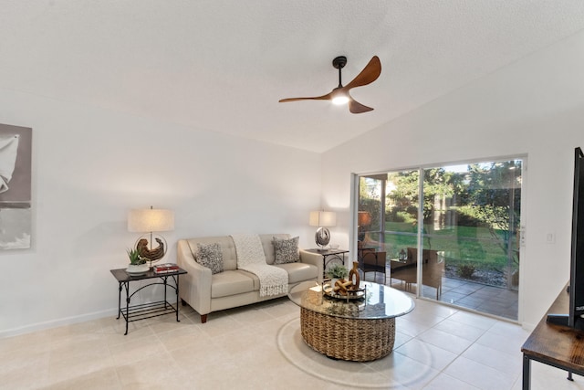 tiled living room with ceiling fan and high vaulted ceiling