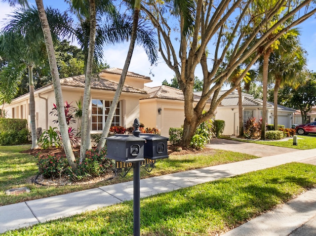 mediterranean / spanish-style house with a garage and a front lawn