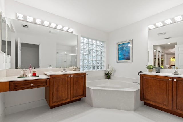 bathroom with plus walk in shower, vanity, and tile patterned flooring