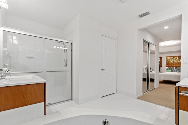 bathroom featuring tile patterned floors, vanity, and a shower with shower door