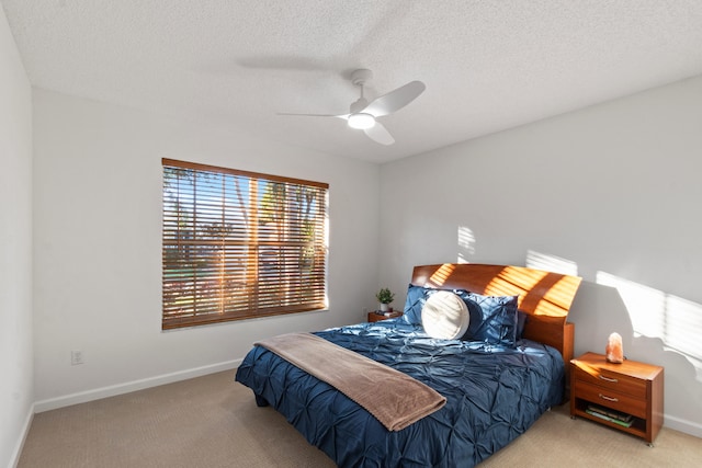 bedroom featuring ceiling fan, light carpet, and a textured ceiling