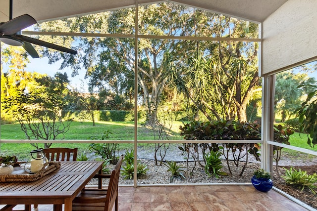 unfurnished sunroom featuring a wealth of natural light, vaulted ceiling, and ceiling fan