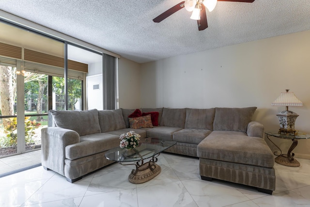 living room with ceiling fan and a textured ceiling