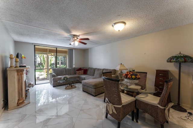 living room featuring ceiling fan and a textured ceiling