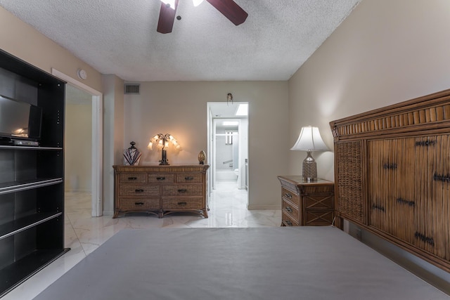 bedroom with ceiling fan and a textured ceiling