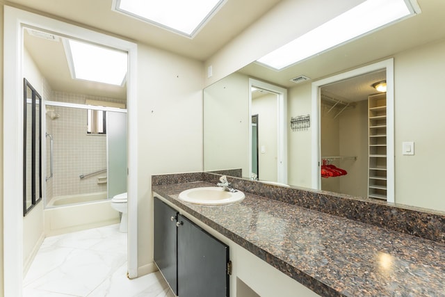 full bathroom featuring toilet, vanity, and combined bath / shower with glass door