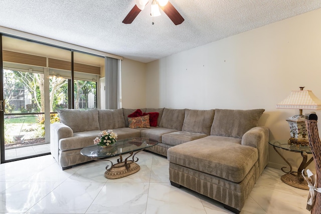 living room with ceiling fan and a textured ceiling