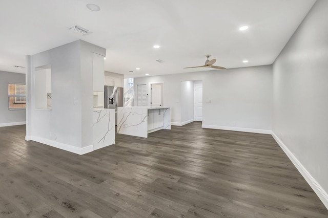 unfurnished living room featuring ceiling fan and dark hardwood / wood-style floors