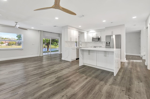 kitchen featuring appliances with stainless steel finishes, a center island, dark hardwood / wood-style flooring, sink, and white cabinetry