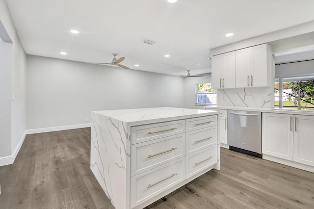 kitchen with dishwasher, a center island, backsplash, white cabinetry, and sink