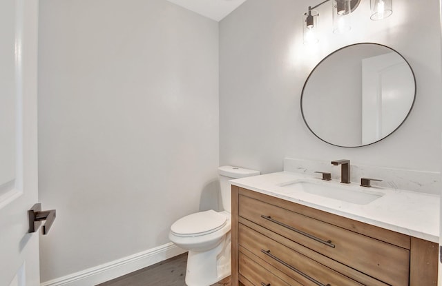 bathroom featuring toilet, vanity, and hardwood / wood-style floors