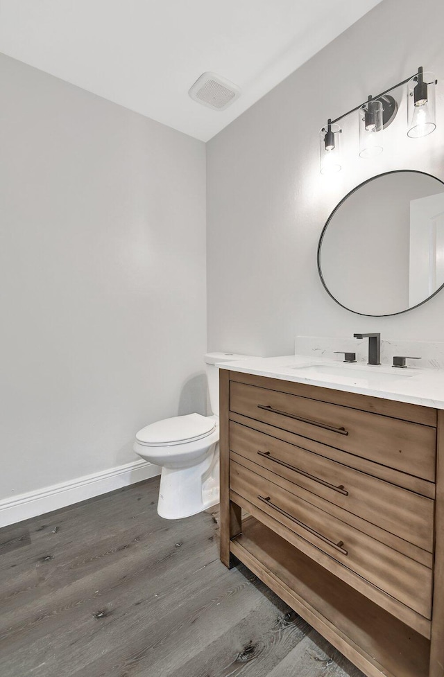 bathroom featuring toilet, hardwood / wood-style flooring, and vanity