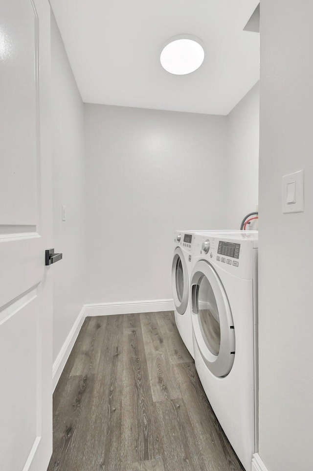 laundry room featuring washing machine and clothes dryer and hardwood / wood-style floors