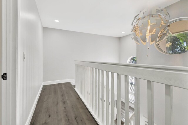 hallway featuring a chandelier and dark wood-type flooring