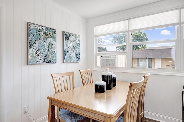 dining room featuring wood walls and cooling unit