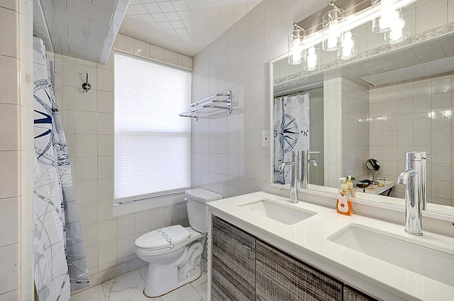 bathroom featuring vanity, toilet, plenty of natural light, and tile walls