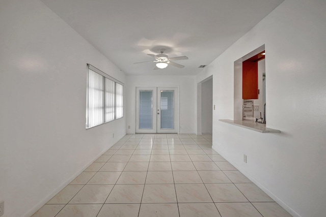 tiled empty room with ceiling fan, sink, and french doors