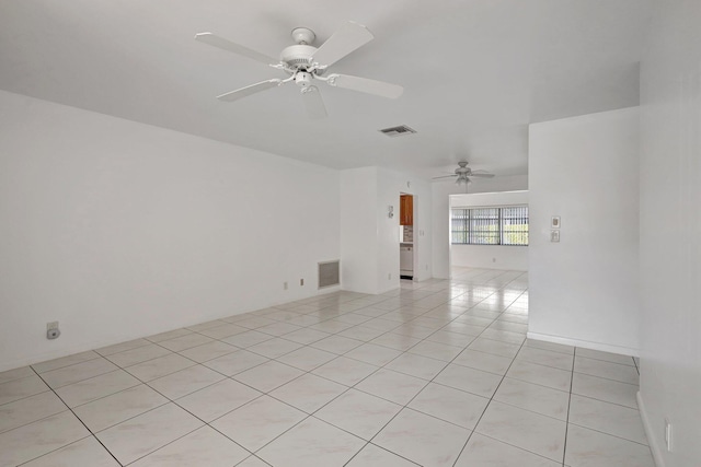 tiled empty room featuring ceiling fan