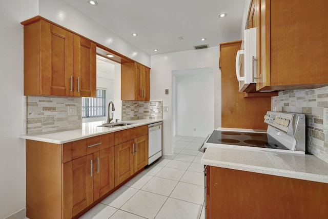 kitchen featuring light stone countertops, sink, white appliances, decorative backsplash, and light tile patterned floors