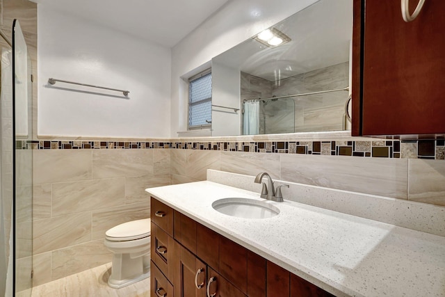 bathroom with a shower with curtain, vanity, tile walls, and toilet