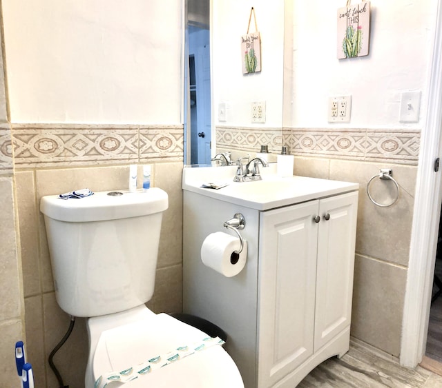 bathroom with hardwood / wood-style flooring, vanity, and tile walls