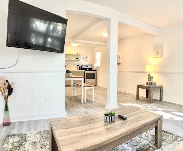 living room with beam ceiling and light wood-type flooring