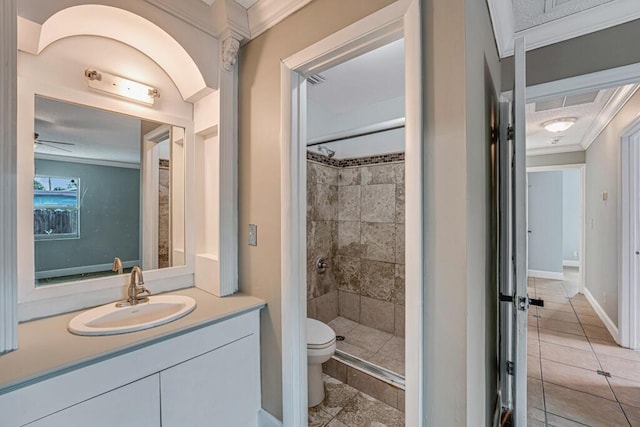 bathroom featuring toilet, a tile shower, ceiling fan, crown molding, and vanity