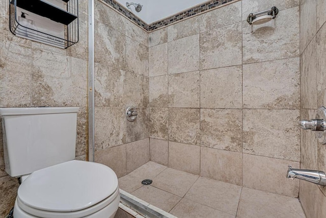 bathroom featuring toilet and a tile shower