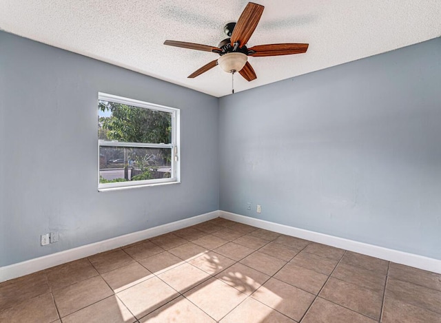 tiled empty room featuring a textured ceiling and ceiling fan