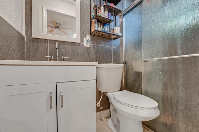 bathroom featuring ceiling fan, toilet, vanity, and a shower with door