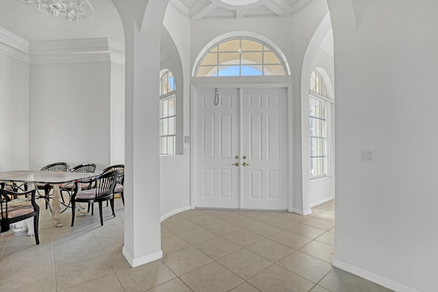 tiled foyer featuring ornamental molding