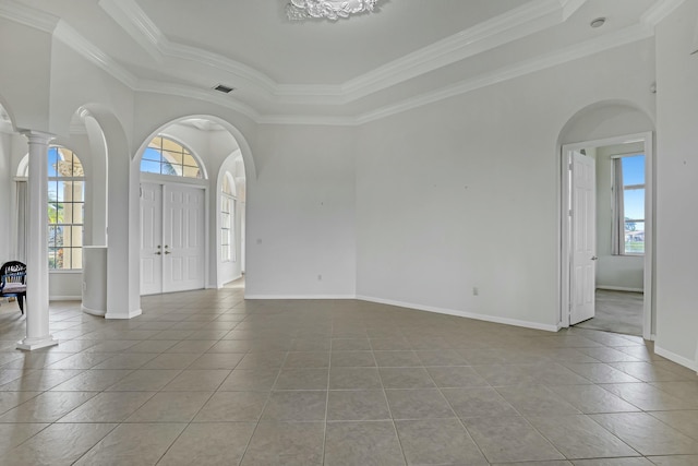 foyer with light tile patterned floors, a tray ceiling, decorative columns, and ornamental molding