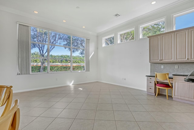 kitchen with decorative backsplash, light brown cabinets, light tile patterned flooring, and ornamental molding