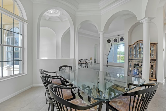 dining area featuring light tile patterned floors, crown molding, and decorative columns