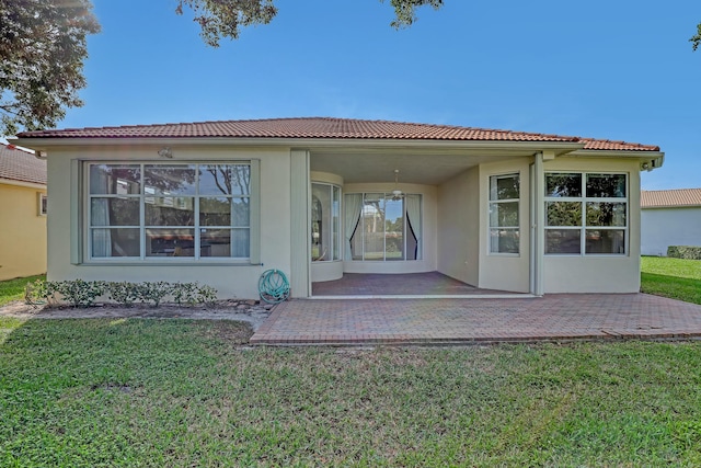 rear view of property with a yard and a patio