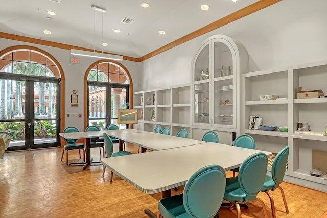 dining area with french doors, light hardwood / wood-style floors, and ornamental molding