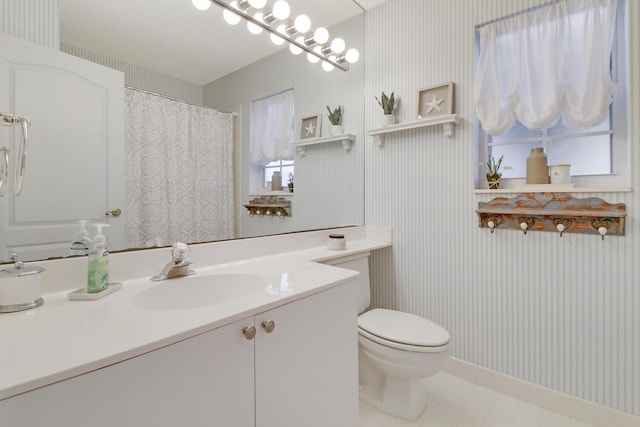 bathroom featuring tile patterned floors, vanity, and toilet