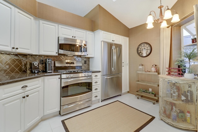 kitchen with pendant lighting, white cabinets, decorative backsplash, stainless steel appliances, and a chandelier