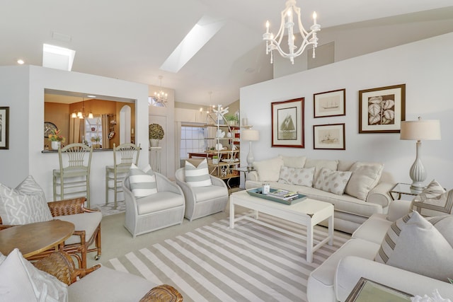 carpeted living room featuring lofted ceiling with skylight and a chandelier