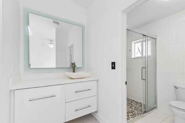 bathroom with ceiling fan, vanity, toilet, and walk in shower