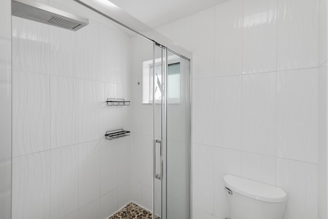 bathroom with walk in shower, tile walls, and toilet