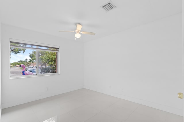 spare room with ceiling fan and light tile patterned floors