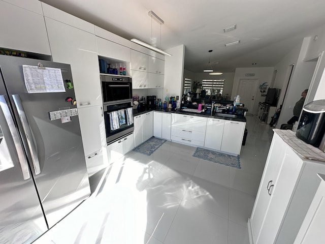 kitchen featuring stainless steel fridge, decorative light fixtures, white cabinetry, and black double oven