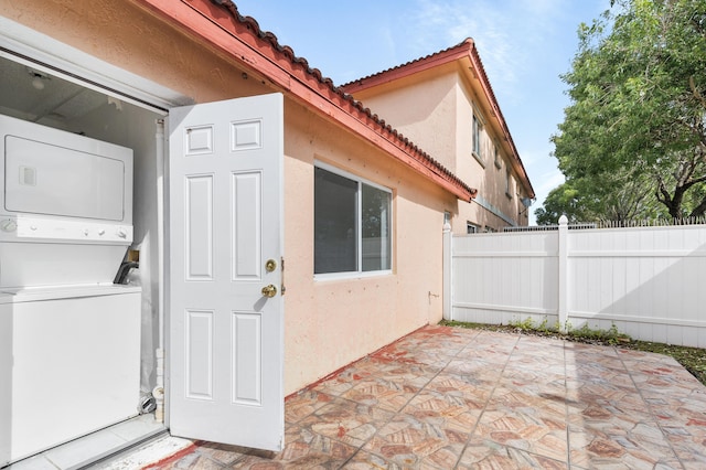 exterior space with stacked washer and clothes dryer