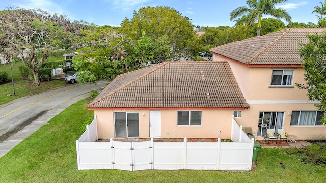 back of house featuring a lawn