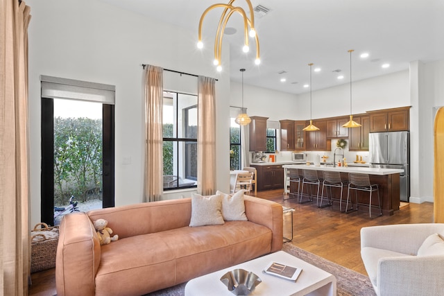 living area with dark wood-type flooring and an inviting chandelier