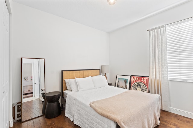 bedroom with a crib and hardwood / wood-style flooring