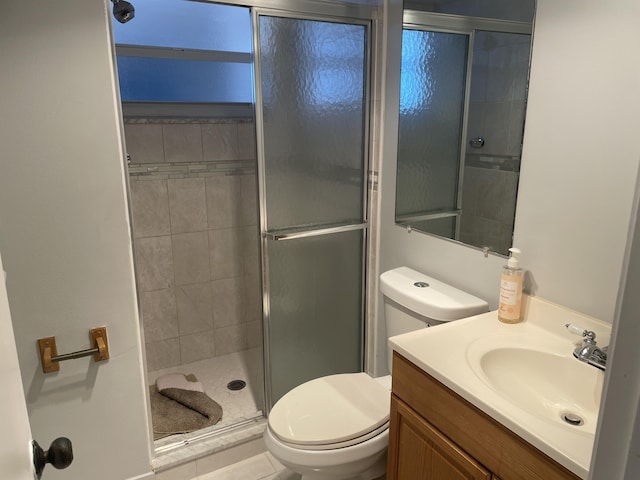 bathroom with a stall shower, vanity, and toilet