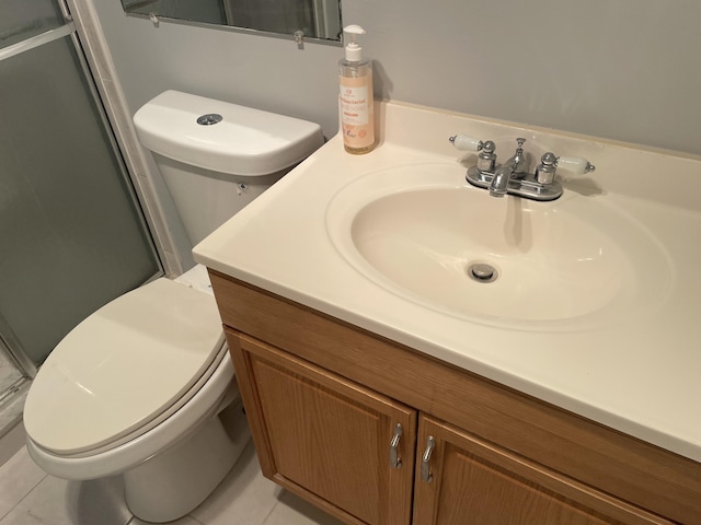 bathroom with a stall shower, tile patterned flooring, vanity, and toilet