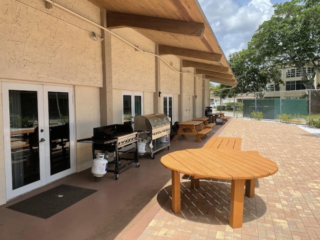 view of patio with french doors, a grill, and fence